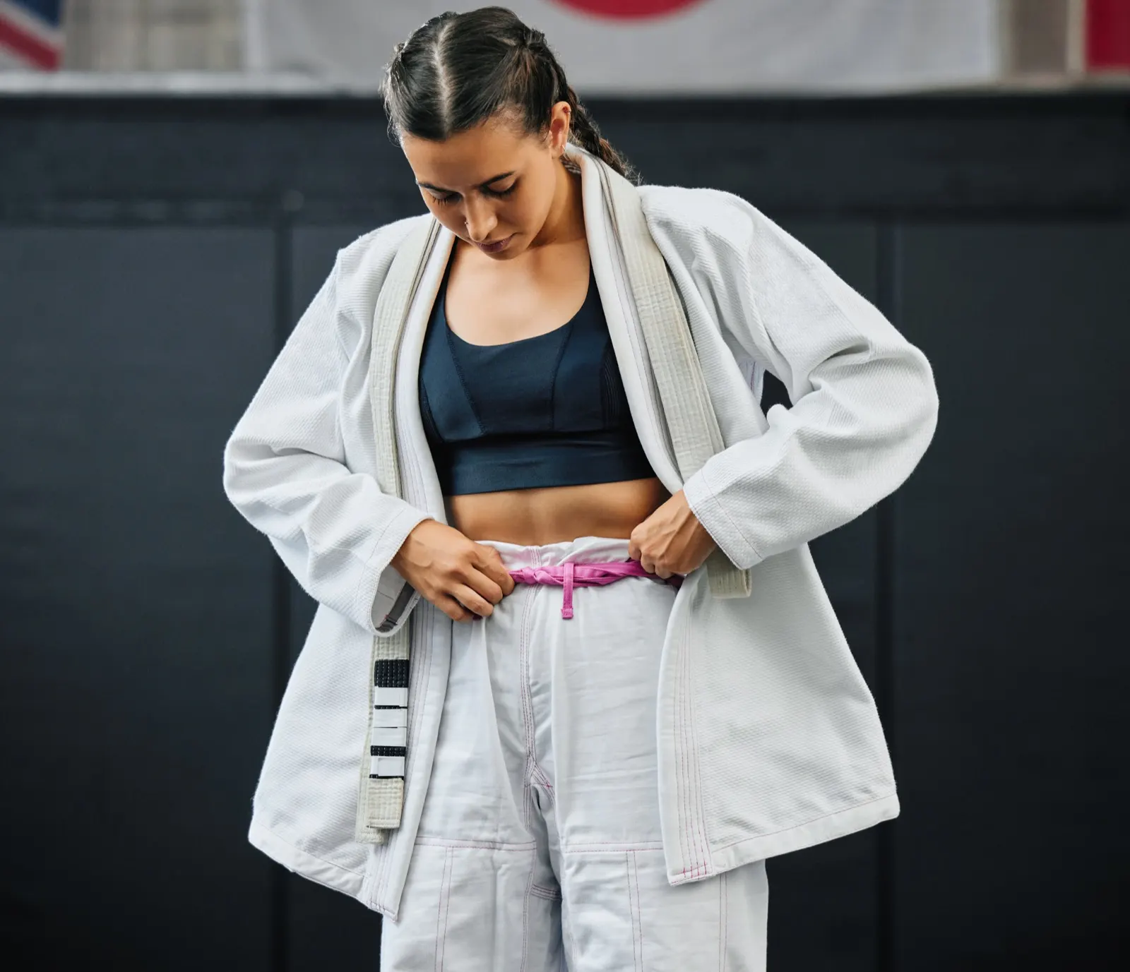 A fighter tying her belt before class