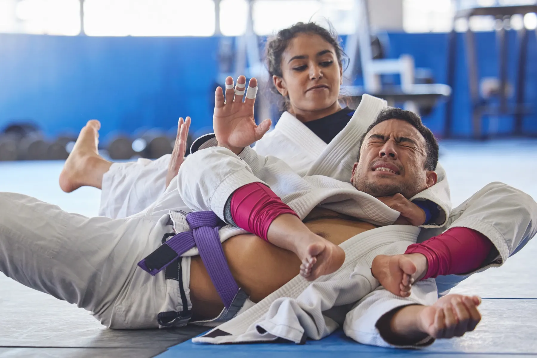 A purple belt holding top position over her training partner